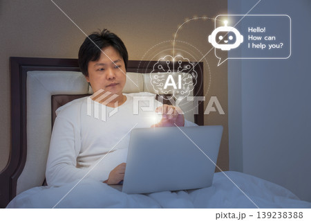 A man sits on a bed using a laptop with glowing AI assistant interface, combining virtual communication with remote work productivity in a home environment. 139238388