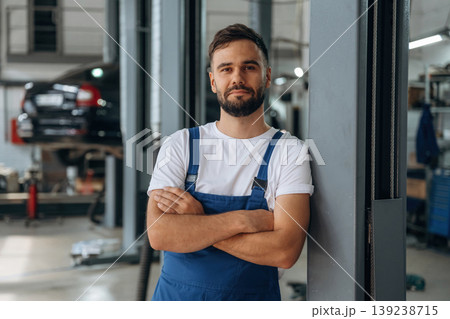 Leaning on the side, standing and posing. Male mechanic is working in the modern car workshop Leaning on the side, standing and posing. Male mechanic is working in the modern car workshop 139238715