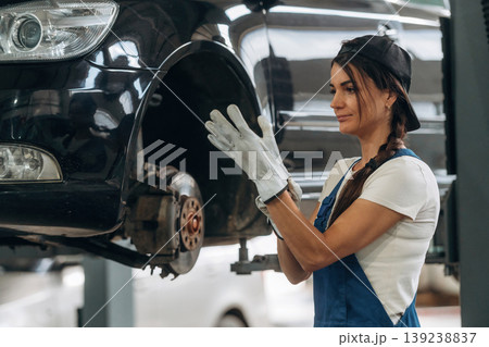 White gloves, wearing them. Female mechanic is working in the modern car workshop 139238837