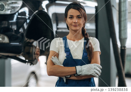 Arms crossed, standing and posing. Female mechanic is working in the modern car workshop 139238838