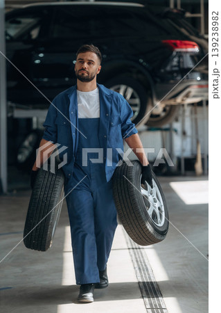 Conception of changing tires, replacing. Male mechanic is working in the modern car workshop 139238982