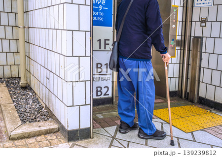 日本の横浜都市景観バリアフリー…改札階ゆきエレベーターを待つ、杖の高齢男性…＝横浜市内 139239812