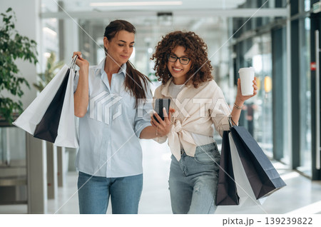 Two female friends are in the supermarket with shopping bags 139239822