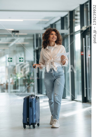 Tourist is with document. Beautiful woman is in airport hall with suitcase 139239932