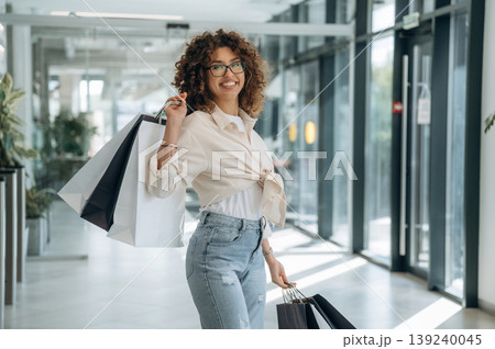 Smiling, feeling good. Woman is with shopping bags indoors in the supermarket Smiling, feeling good. Woman is with shopping bags indoors in the supermarket 139240045