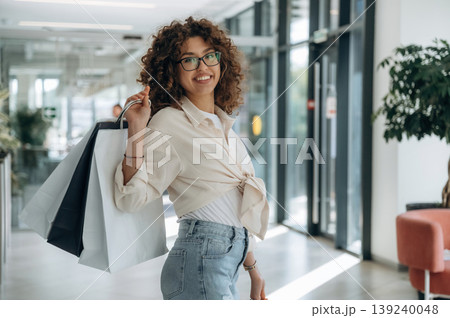 Smiling, feeling good. Woman is with shopping bags indoors in the supermarket 139240048