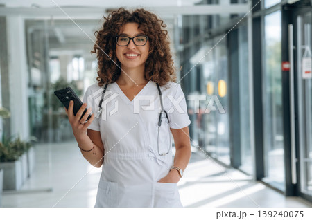 Clinic and healthcare conception. Woman doctor is standing indoors in the clinic 139240075
