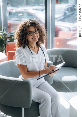 Clinic and healthcare conception. Woman doctor is standing indoors in the clinic 139240077