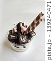 A decadent dessert with yogurt, brownie, marshmallows, and wafer rolls, topped with chocolate syrup 139240471