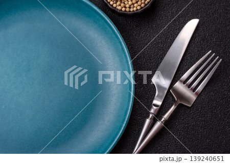 An empty ceramic round plate, kitchen utensils for a dinner table. An empty plate An empty ceramic round plate, kitchen utensils for a dinner table. An empty plate 139240651