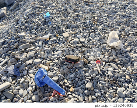 The pebble beach is littered with trash thrown from the sea The pebble beach is littered with trash thrown from the sea 139240939