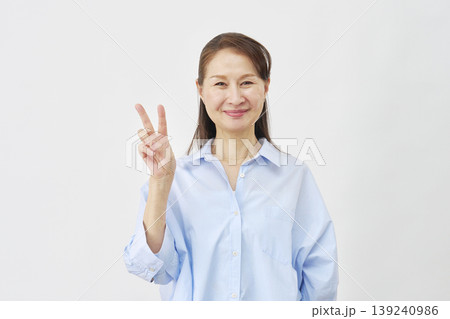 白背景でピースサインをする女性 139240986