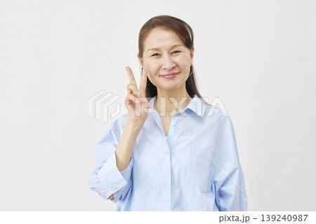 白背景でピースサインをする女性 139240987