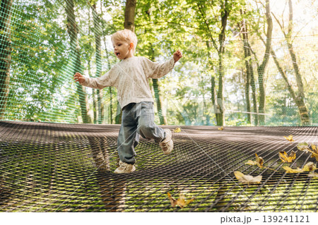 Little boy is playing on the children's amusement ropes course 139241121