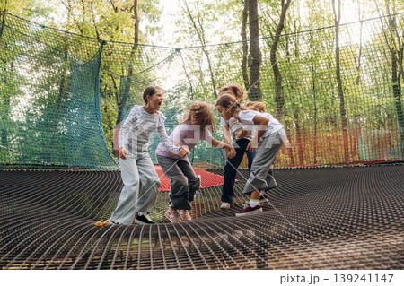 Enjoying, having fun. Kids are playing on the children's amusement ropes course Enjoying, having fun. Kids are playing on the children's amusement ropes course 139241147