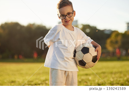 Game of soccer, with ball, competitive sport. Boy is having fun on the field under sunlight at daytime 139241589