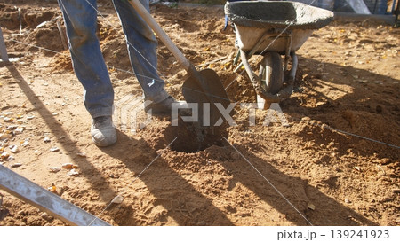 worker shovels trench, worker digs and fills trench with shovel, worker utilizes shovel to fill trench and transfer material, worker uses shovel to fill trench and move material efficiently 139241923