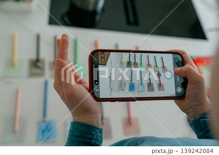 Hands holding smartphone taking a photo of objects. Concept of mobile photography, social media content creation, and modern technology use. 139242084