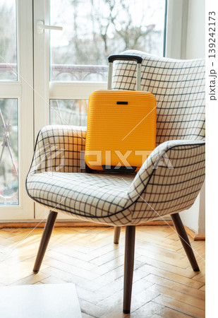 Yellow suitcase on armchair ready for travel Yellow suitcase on armchair ready for travel 139242173