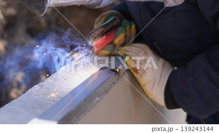 Welder Finishing Seam With Torch And Careful Hand Control, Sparks And Smoke Rising Closeup Of Bead Smoothing And Surface Cleaning On Structural Steel, Gloved Hand And Protective Clothing 139243144
