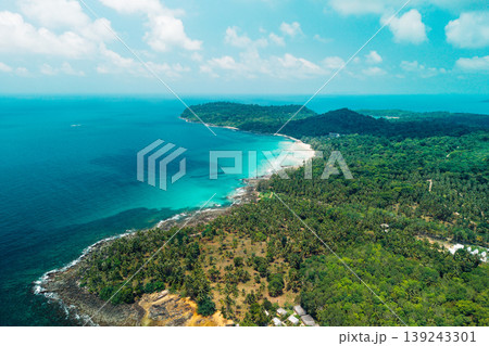 Bright midday sunlight reflecting on clear blue coastal waters and beach. 139243301