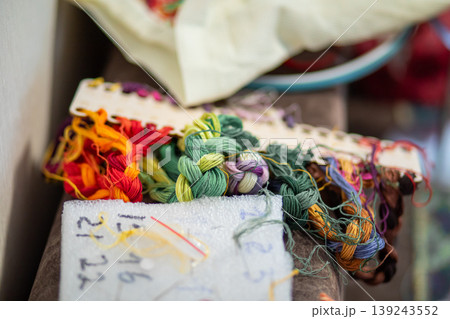 Colorful embroidery floss threads organized on cardboard holder. Needlework supplies for cross stitch and sewing craft. Hobby and creative needlecraft accessorize for textile design project. 139243552