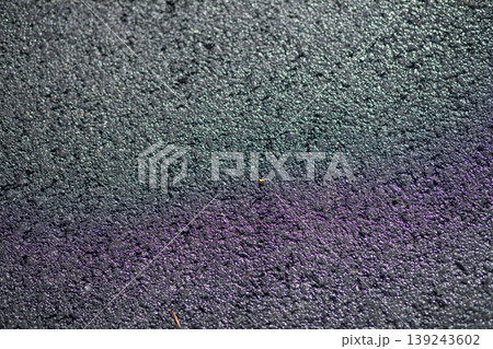 Dark wet asphalt road surface with abstract rainbow oil reflection. Texture of coarse pavement with raindrop after heavy rain. Background for urban city street or transportation concept. 139243602