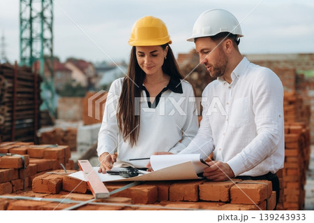 Female manager and male builder are on the construction site Female manager and male builder are on the construction site 139243933