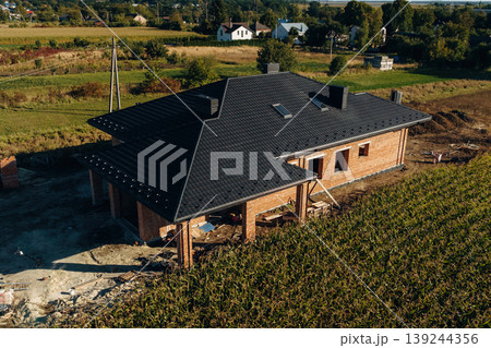 In the rural areal. Aerial view of unfinished house at daytime illuminated by sunlight 139244356