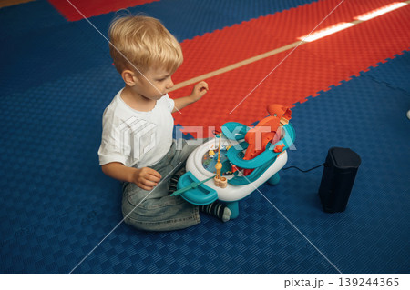 Fishing simulator toy. Cute preschool child, boy, during developmental activities in a playroom Fishing simulator toy. Cute preschool child, boy, during developmental activities in a playroom 139244365
