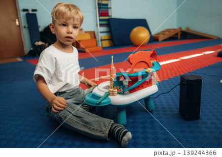 Fishing simulator toy. Cute preschool child, boy, during developmental activities in a playroom Fishing simulator toy. Cute preschool child, boy, during developmental activities in a playroom 139244366