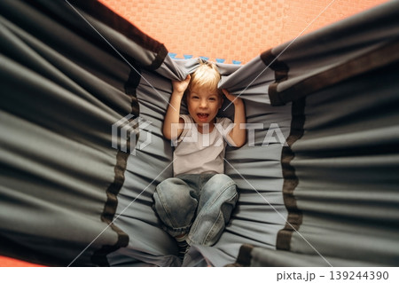 Lying down in the hammock. Cute preschool child, boy, during developmental activities in a playroom 139244390