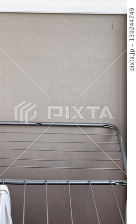 Minimalist Laundry Drying Rack Against Textured Wall 139244749