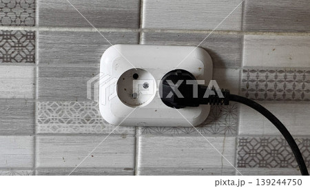 Modern Electrical Outlet with Plug on Stylish Tile Wall Modern Electrical Outlet with Plug on Stylish Tile Wall 139244750