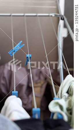 Colorful Clothespins Holding Laundry on Drying Rack 139244781