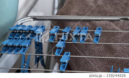 Blue Clothespins on Drying Rack with Soft Towel Background 139244826