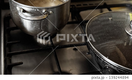 Cooking in a Modern Kitchen with Stainless Steel Pots Cooking in a Modern Kitchen with Stainless Steel Pots 139244894