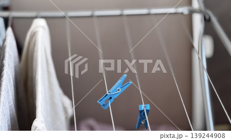 Freshly Laundered Clothes Hanging to Dry with Clothespins Freshly Laundered Clothes Hanging to Dry with Clothespins 139244908