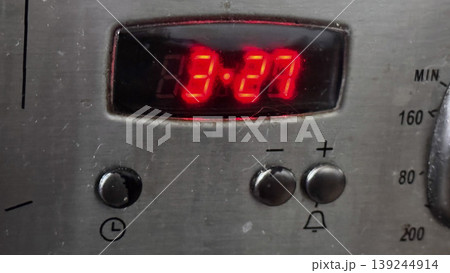 Digital Timer Display on Kitchen Appliance with Red LED Lights 139244914