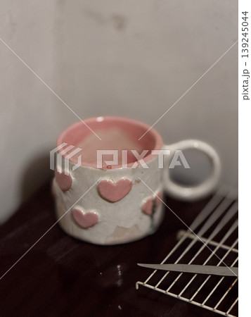 Charming Heart-Embellished Ceramic Mug on Wooden Surface 139245044
