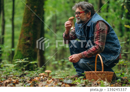 Focused, sitting and checking if it's safe one. Mushroom picking. Man is in the forest at daytime 139245337