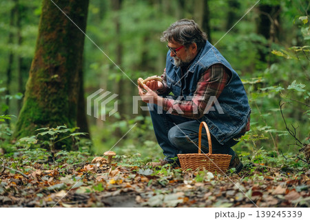 Identification if it's safe one. Mushroom picking. Man is in the forest at daytime 139245339