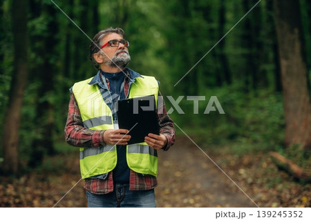 Senior forest ecologist is working in the woods. In the uniform Senior forest ecologist is working in the woods. In the uniform 139245352