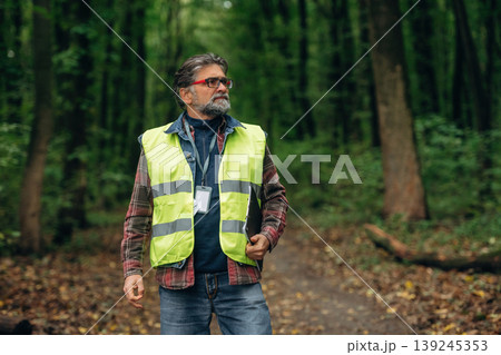 Senior forest ecologist is working in the woods. In the uniform 139245353