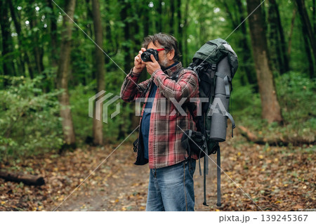 Hiking experience, senior man is in the forest at daytime Hiking experience, senior man is in the forest at daytime 139245367
