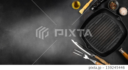 Dark cooking background with grill pan and spices with copy space for premium steakhouse advertising and food branding Dark cooking background with grill pan and spices with copy space for premium steakhouse advertising and food branding 139245446