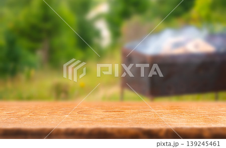 Empty wooden table with blurred barbecue grill in green garden background summer outdoor food banner 139245461