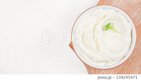 Cream cheese in bowl with microgreens on wooden board, soft spread texture, minimal food background with copy space Cream cheese in bowl with microgreens on wooden board, soft spread texture, minimal food background with copy space 139245471