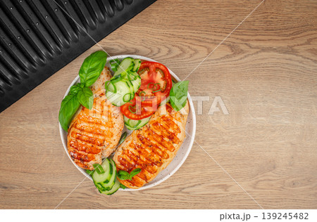 Grilled chicken breast with fresh vegetables on wooden table top view healthy diet meal with copy space 139245482
