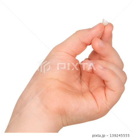 Child hand holding lost baby tooth isolated on white background tooth fairy and dental concept 139245555